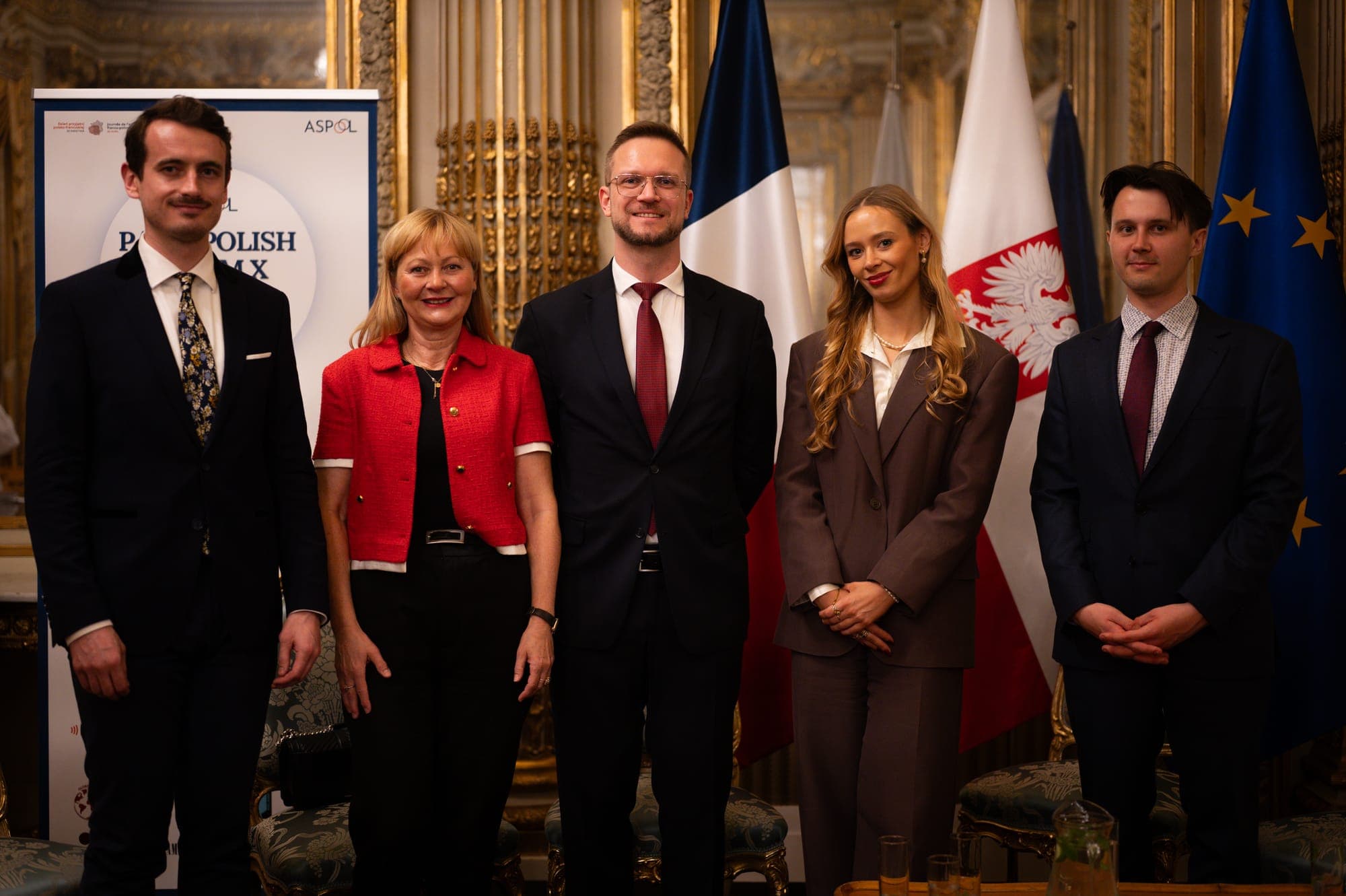 Speakers and organisers posing in front of the Paris Polish Forum X banner