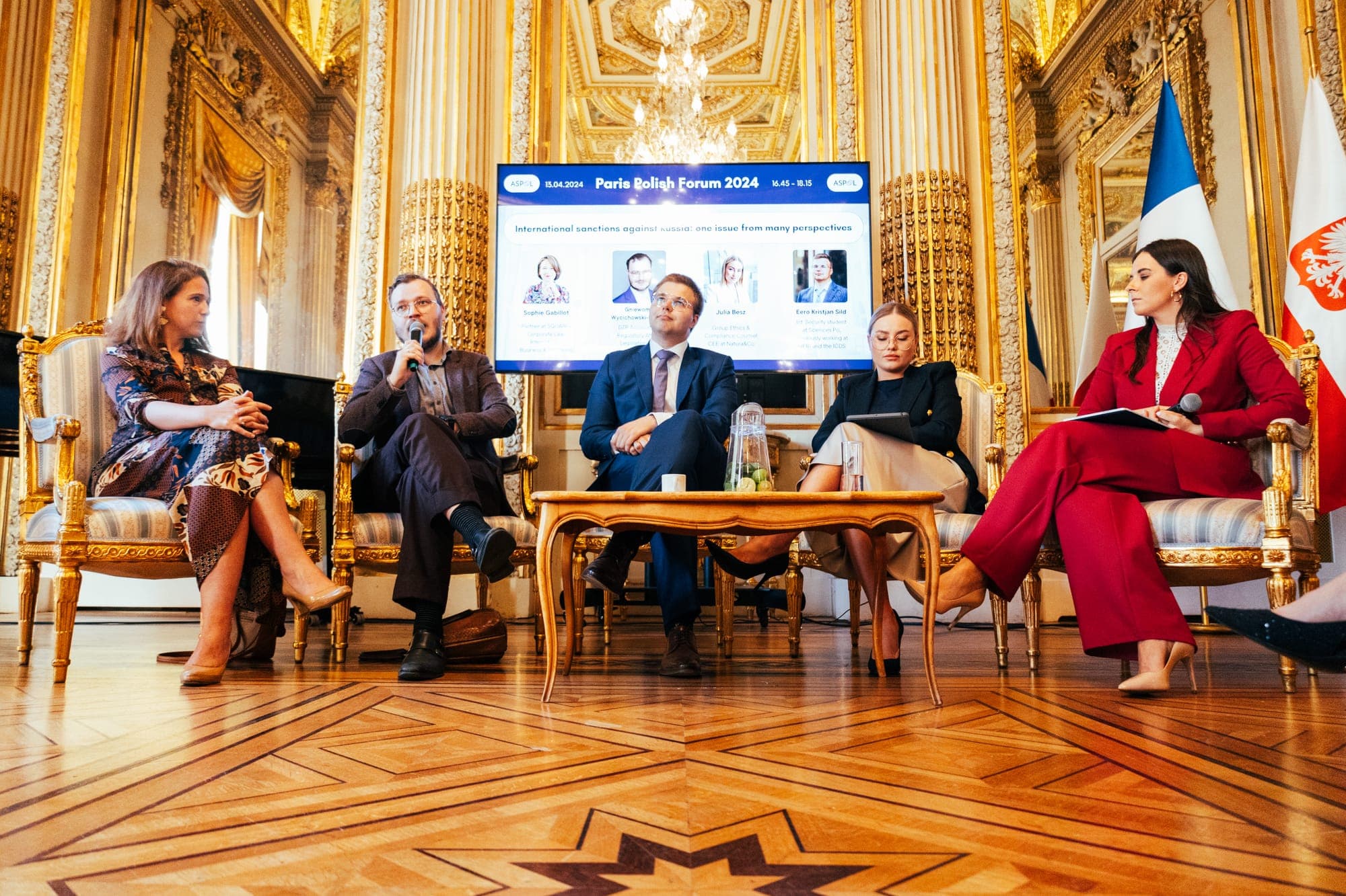 Five speakers on stage under the Paris Polish Forum 2024 screen